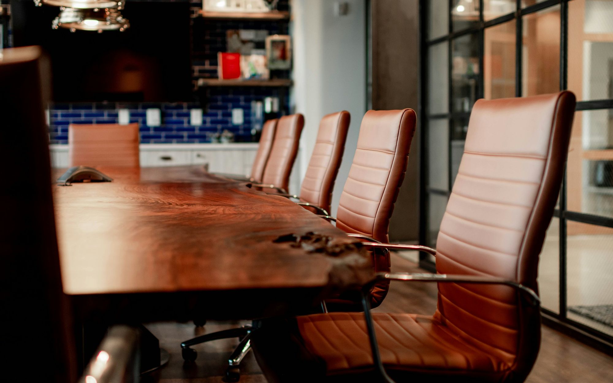 Executive boardroom with a long wooden table and leather chairs