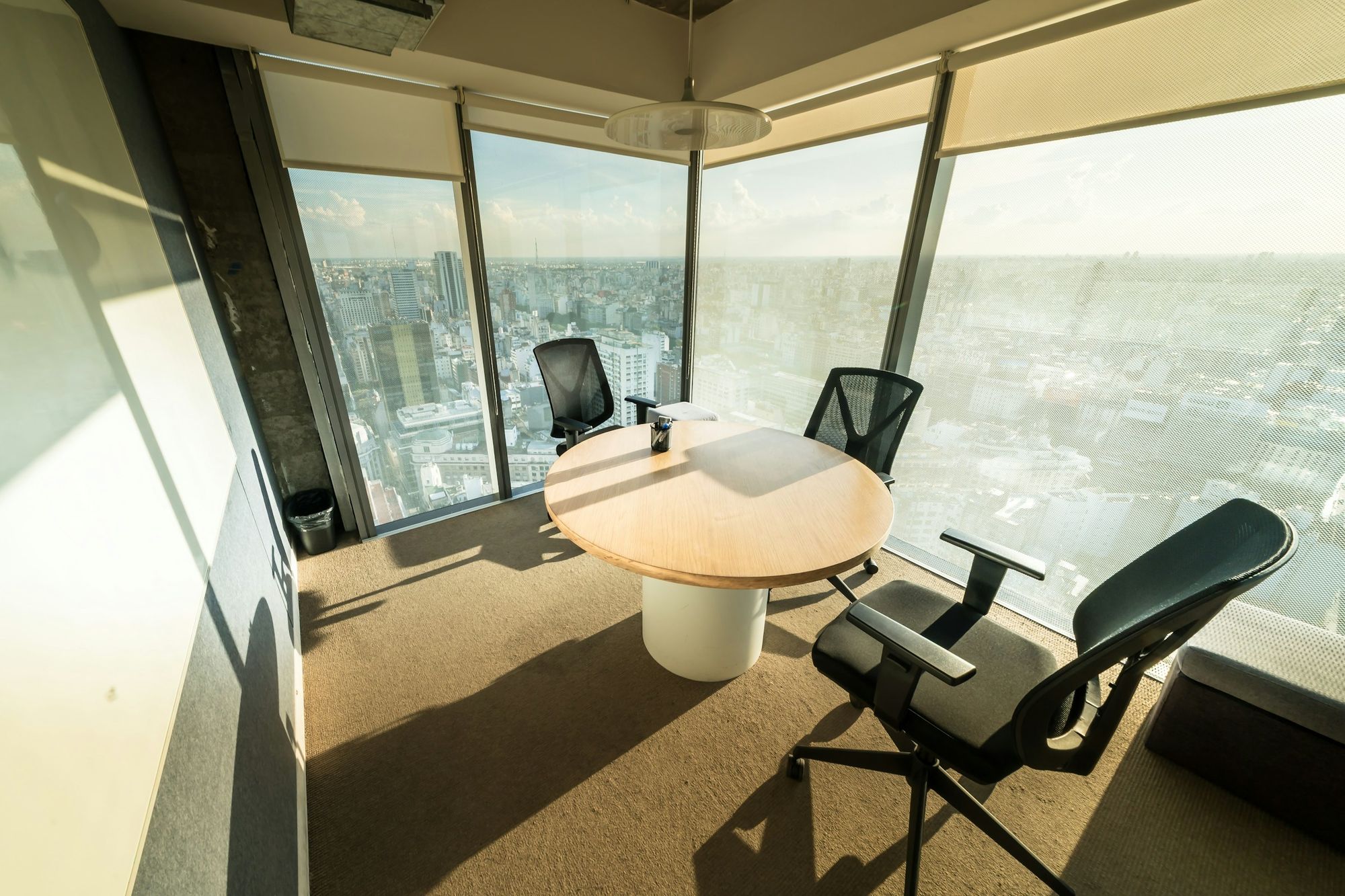 Quiet meeting room with floor-to-ceiling windows over a city